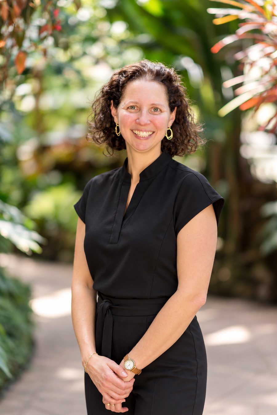 Dr. Bernice Teplitsky smiling on a garden path, wearing a black dress